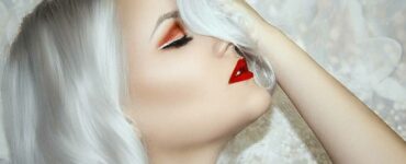 Mujer con piel bella y labios pintados de rojo.